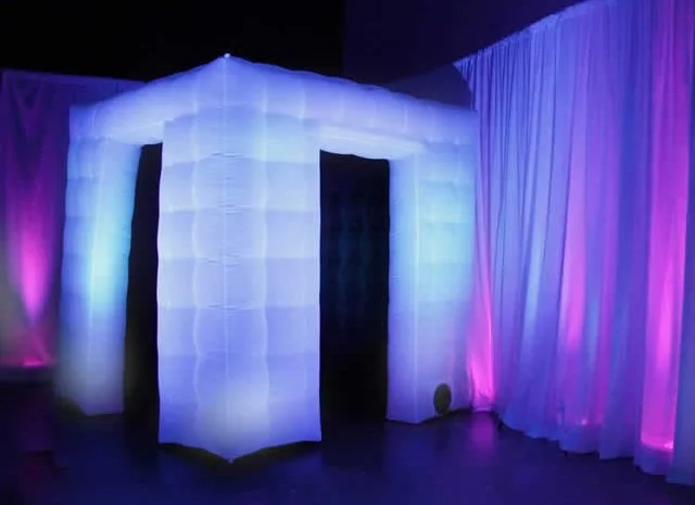 Luminescent inflatable structure with blue and purple lighting in an indoor setting.