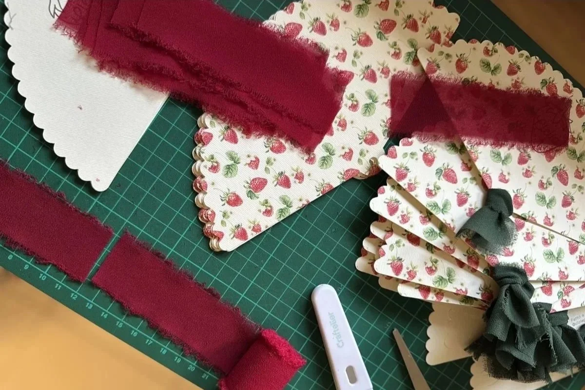 Tavolo da lavoro con ventagli personalizzati per festa bambina a tema fragole