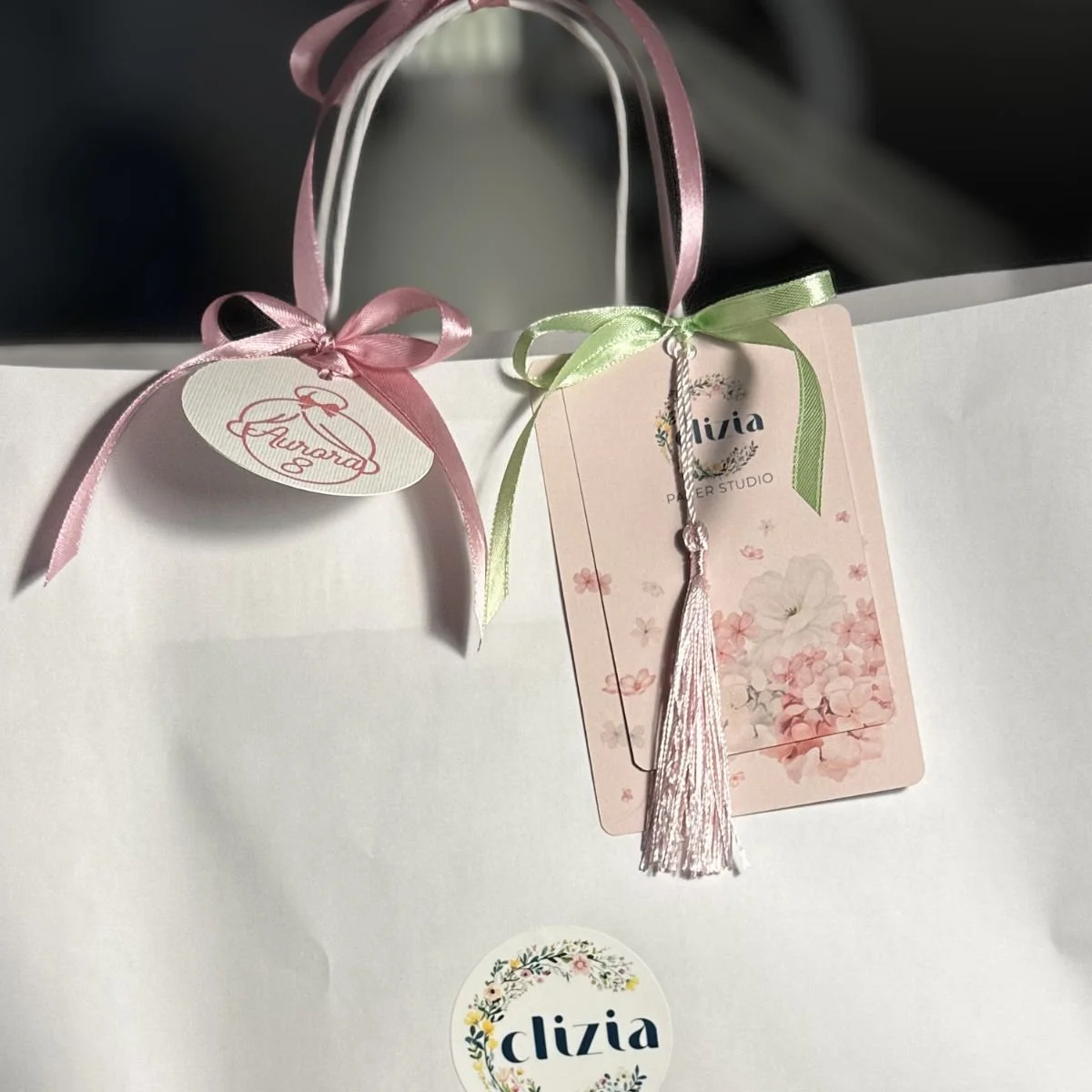Sacchetto regalo bianco decorato con nastri rosa e verde e cartellino personalizzato Clizia Paper Studio.