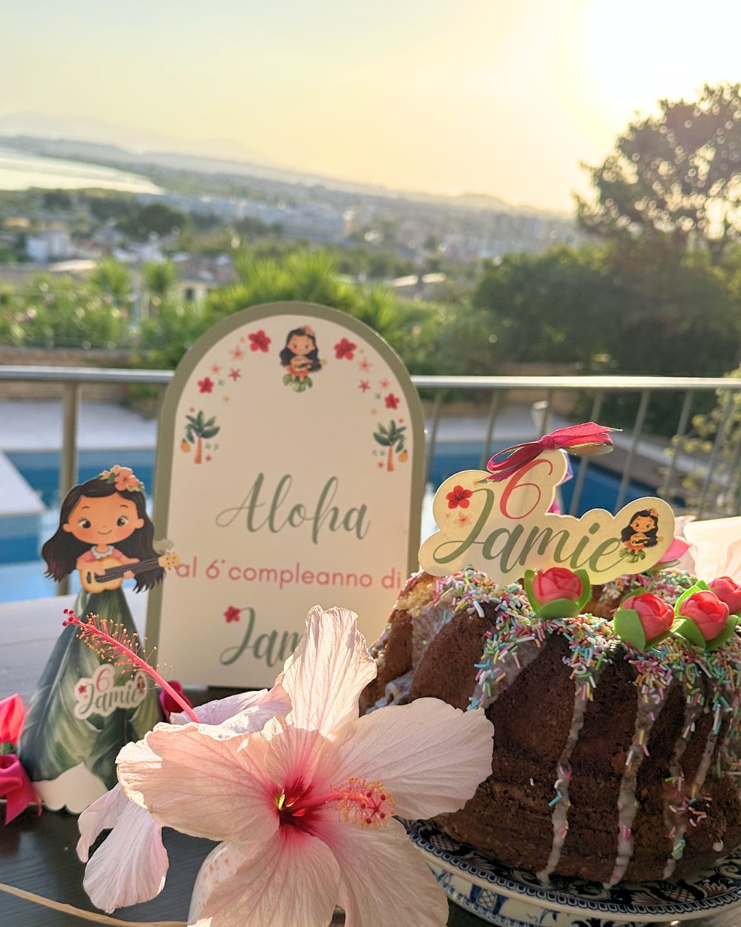 Allestimento compleanno a tema tropicale Hawaii con cartello di benvenuto personalizzato e decorazioni coordinate.