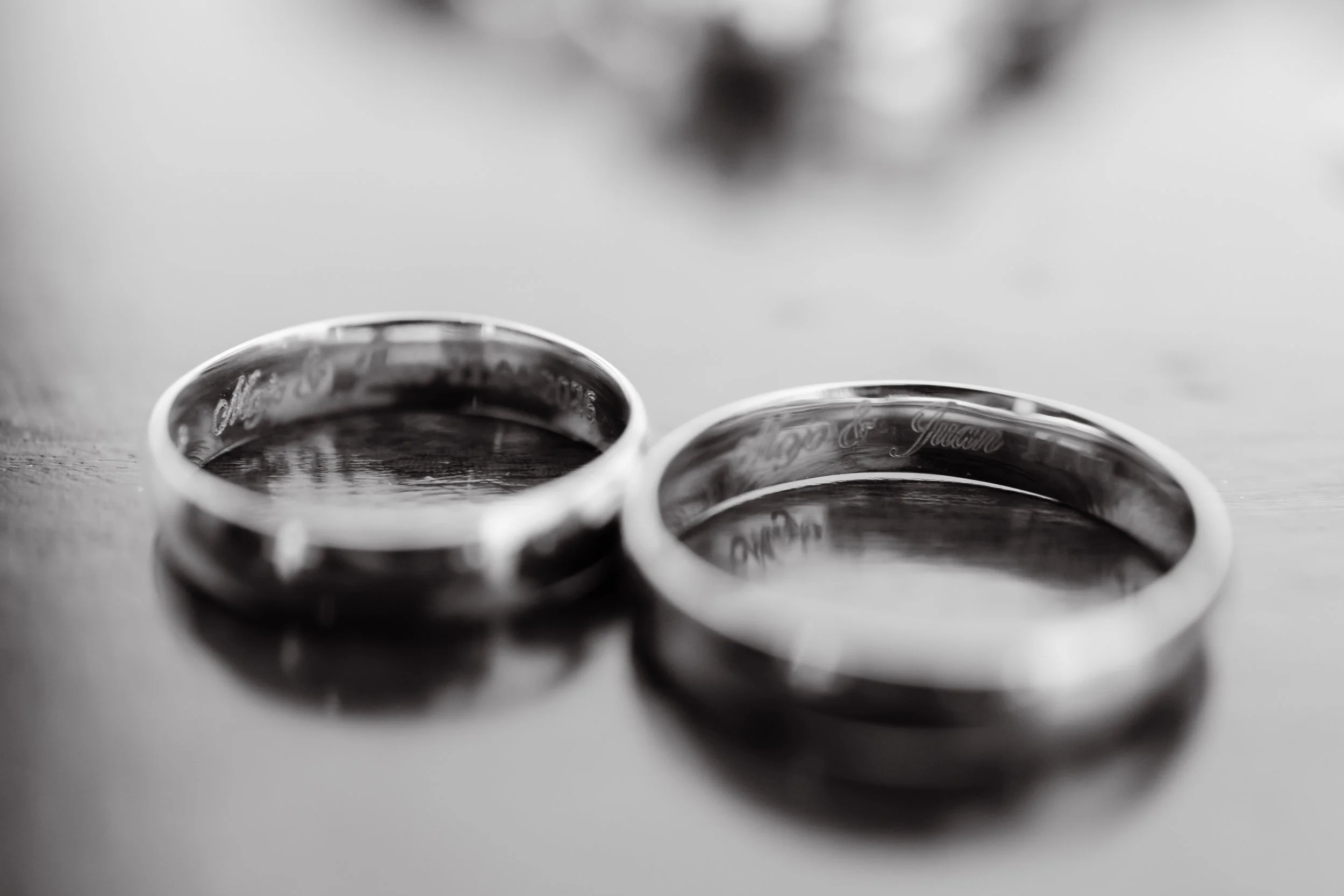 Dos anillos de plata entrelazados sobre una superficie plana.