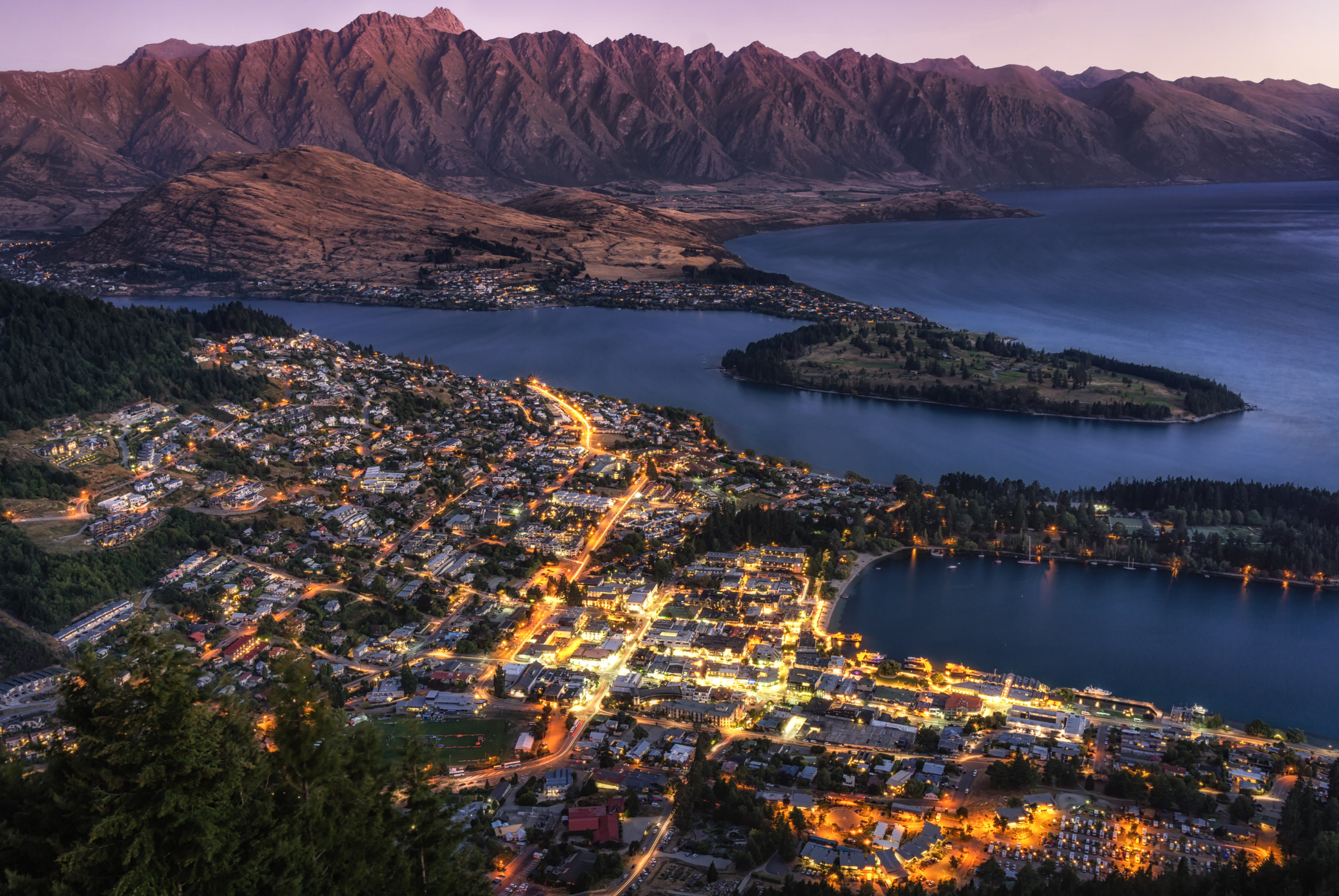 Aerial view of Queenstown and Lake Wakatipu at dusk, showcasing the luxury real estate accessible to Active Investor Plus visa holders.