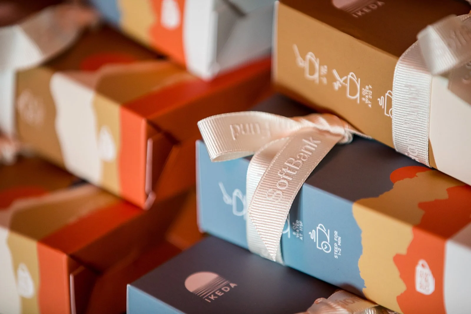 Stacked gift boxes wrapped with colorful paper and tied with white ribbon.