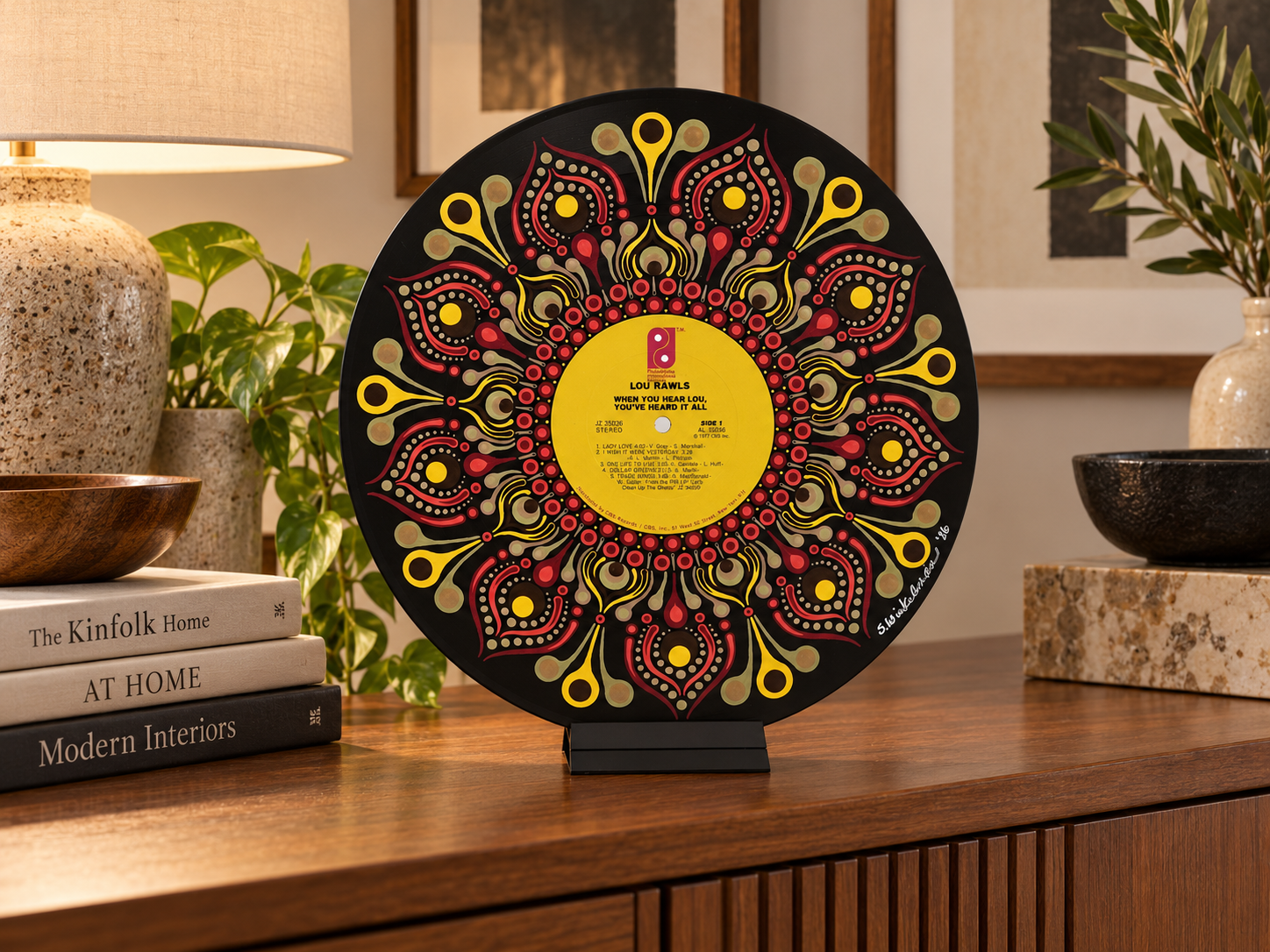 Lou Rawls hand-painted vinyl record art displayed on a tabletop stand in a warm contemporary room