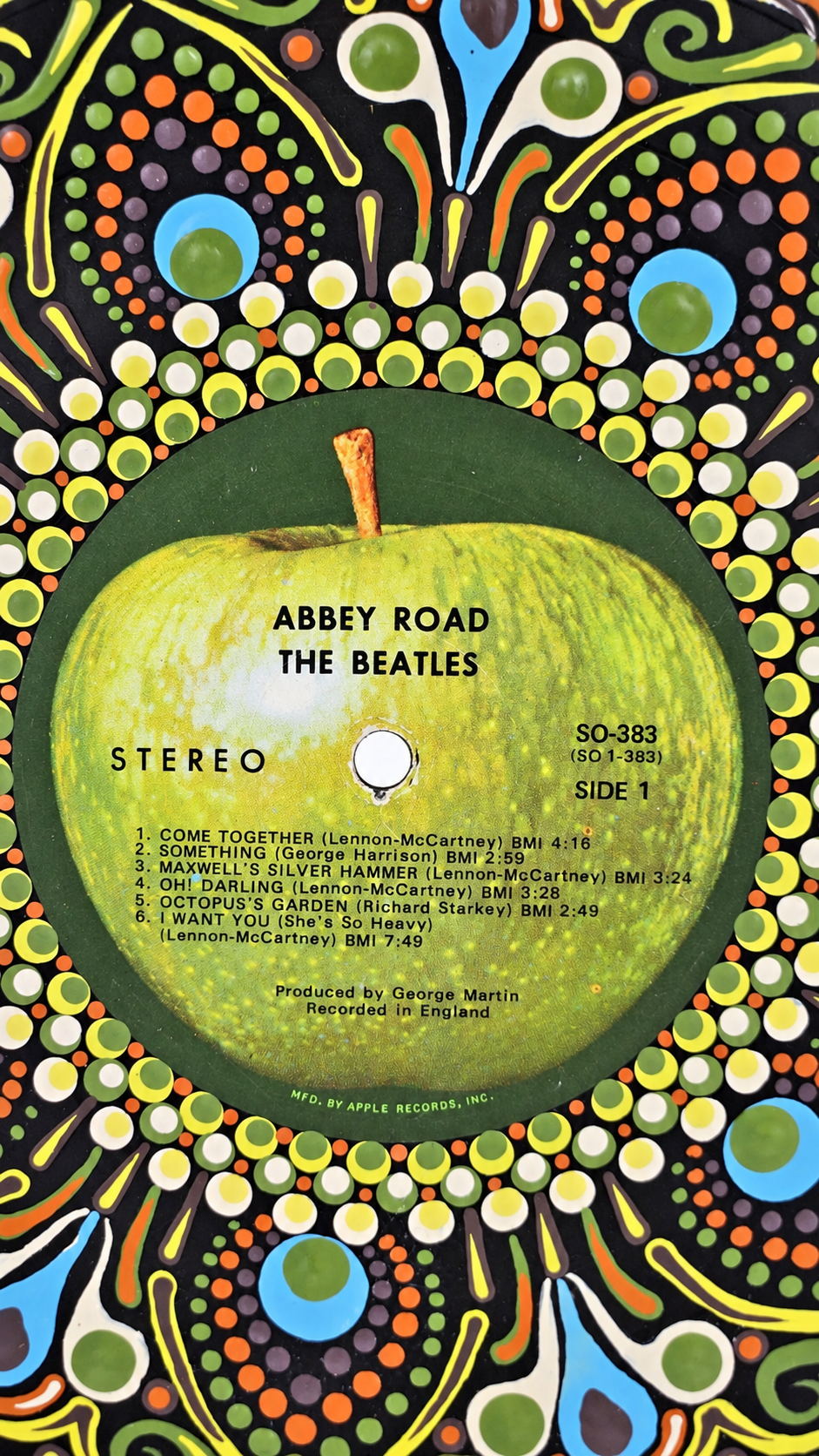 Close-up of the original Apple Records label on a hand-painted Beatles Abbey Road vinyl record.