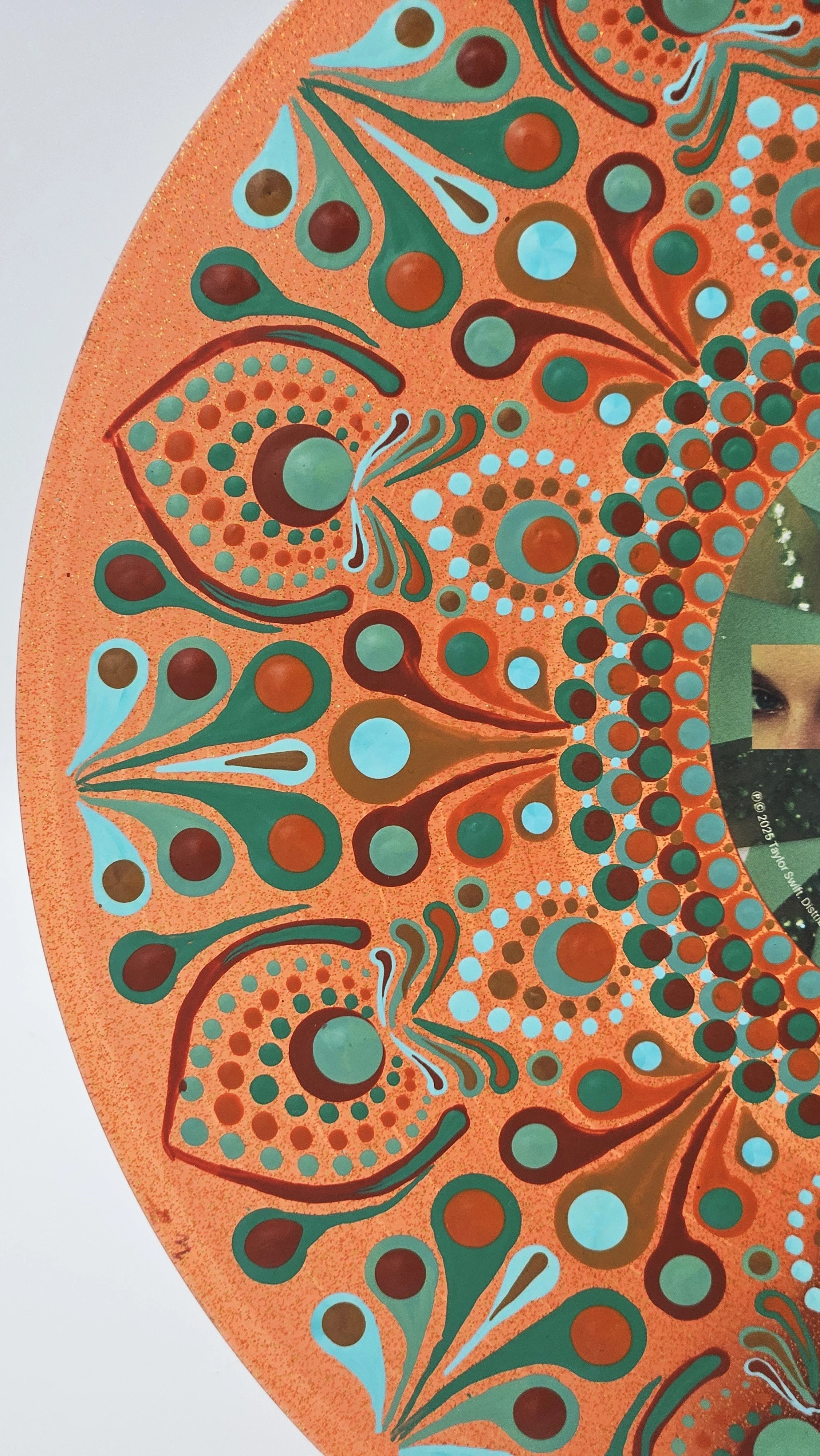 Close-up of hand-painted mandala details on Taylor Swift vinyl record, showing raised acrylic paint drops, turquoise and burgundy flourishes, and intricate patterns on sparkling orange.