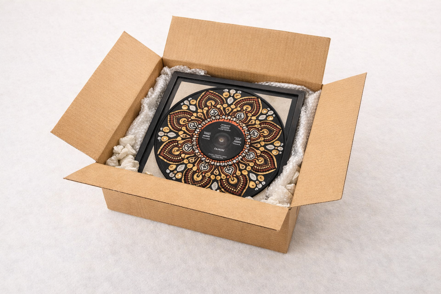 An open box with a framed vinyl record showing packaging peanuts and bubble wrap