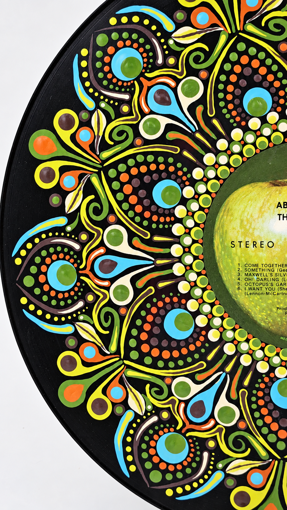 Close-up detail of the hand-painted mandala design on a Beatles Abbey Road vinyl record.