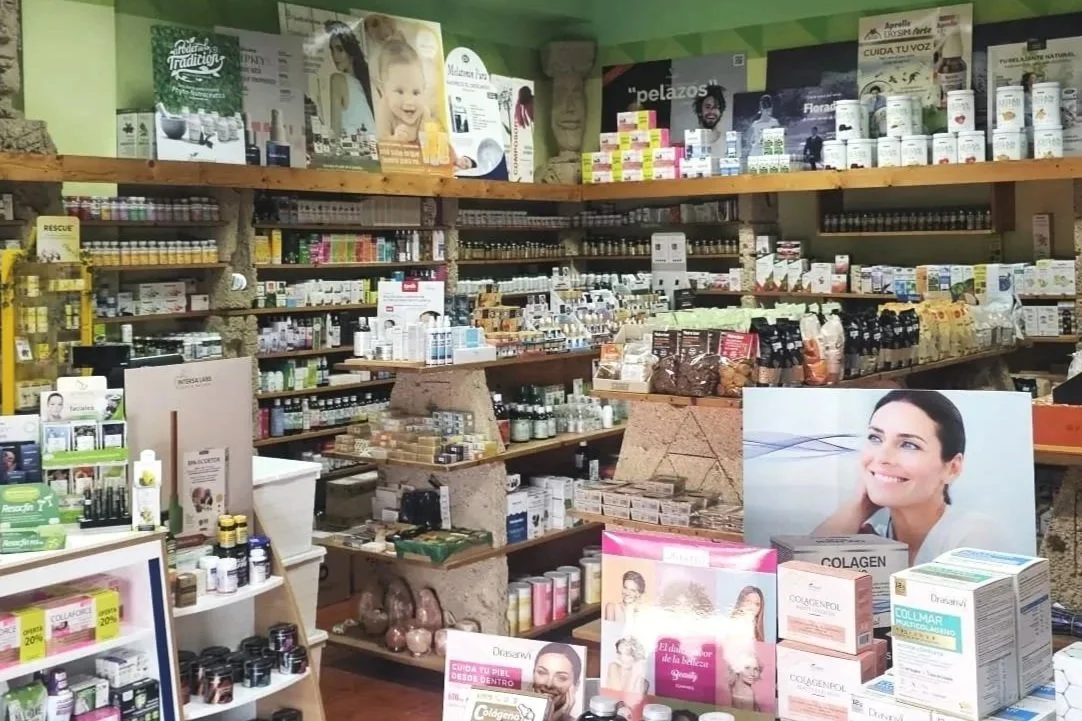 Interior de una tienda de productos naturistas con estantes llenos de frascos y cajas de suplementos y medicamentos naturales.