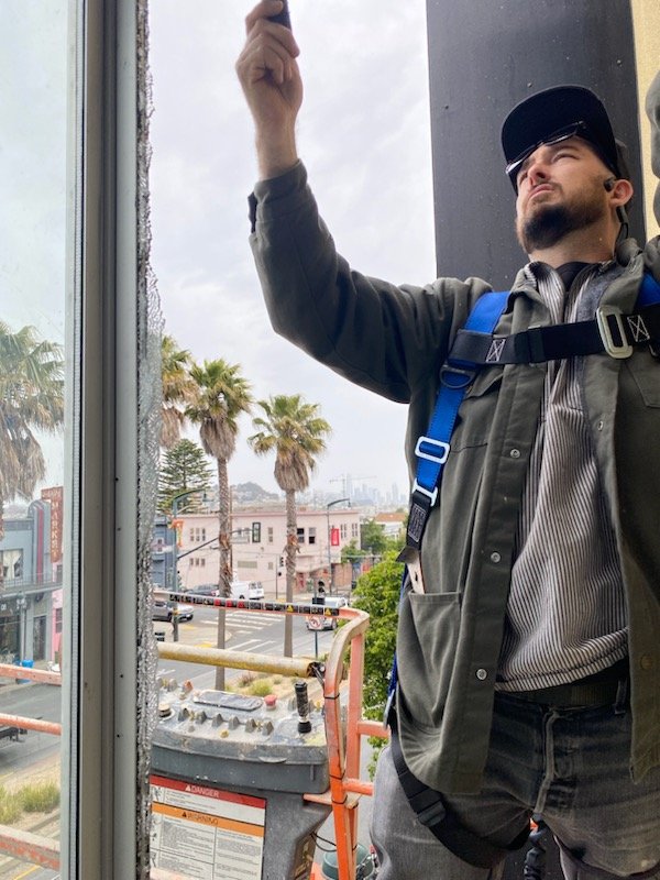 Our glazier installing a large insulated glass to a window on the upper floor from a commercial building