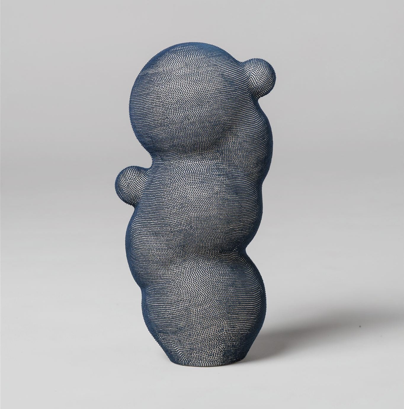 Mamanas III. Stoneware sculpture with hand applied blue engobe dots, composed of an elongated organic form with rounded protrusions.