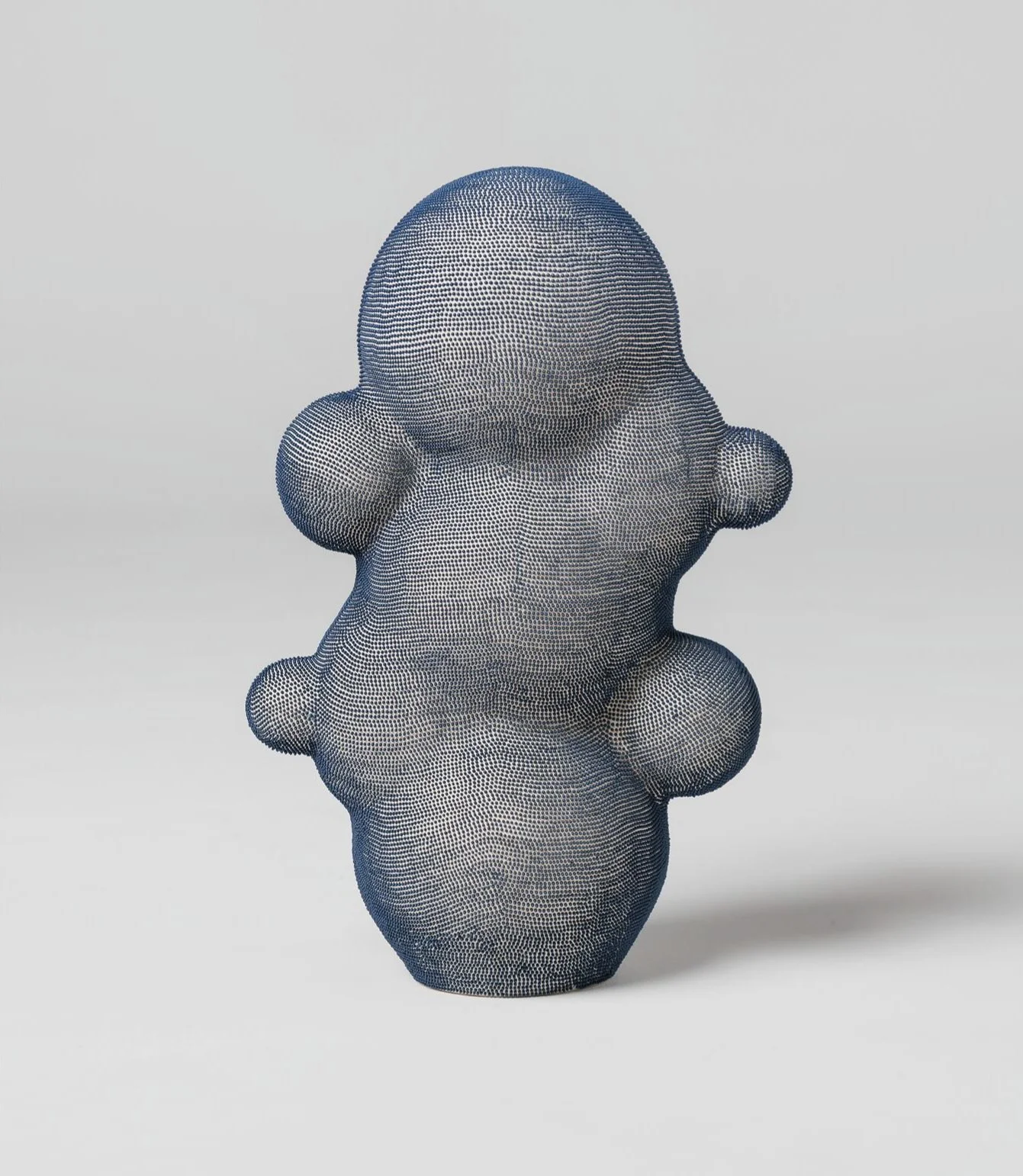 Mamanas II. Stoneware sculpture has an organic silhouette and figurative, feminine form. It is characterised by rounded volumes and skin of blue engobe dots that have been applied by hand, creating a rhythmic, tactile texture on the light surface.