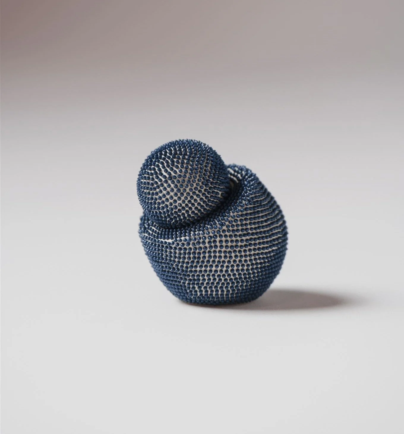 A contemporary ceramic sugar bowl from the same tea service, the piece features a biomorphic, asymmetrical design consisting of two rounded interlocking forms.