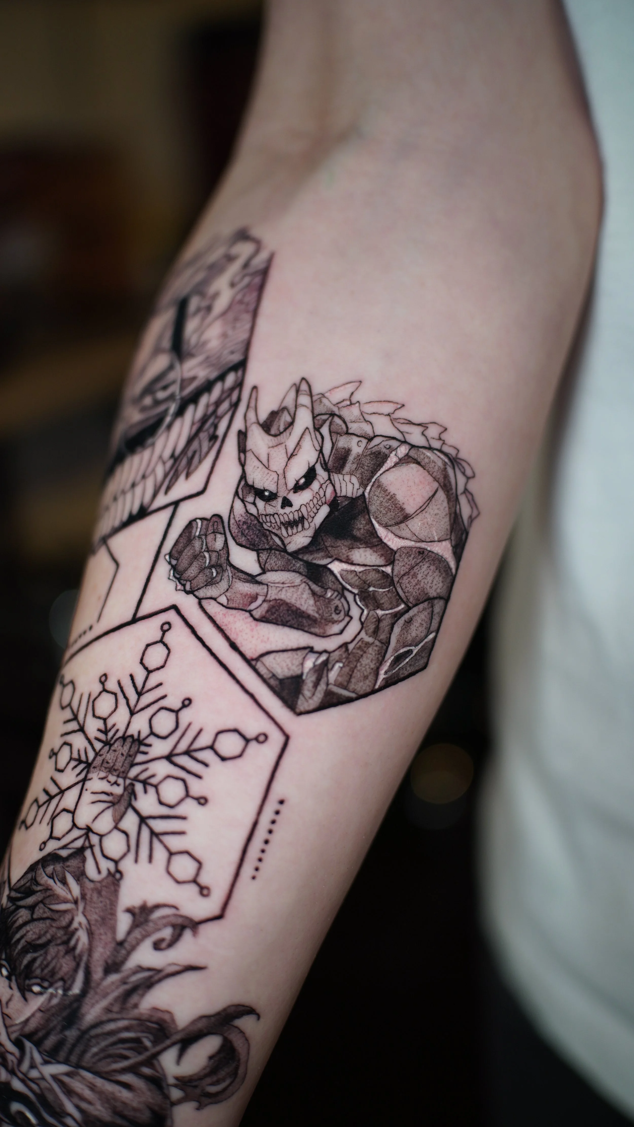 Tattoo of a fierce, skull-faced warrior with armor and wings on a person's arm.