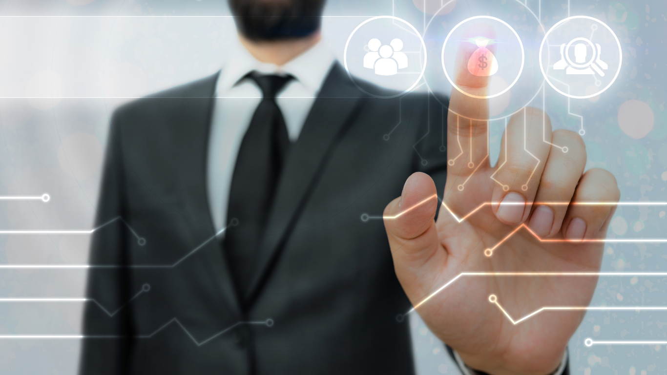 A person in a business suit interacts with a virtual touchscreen featuring icons for people, dollar signs, and magnifying glasses, suggesting themes of business, finance, or technology.