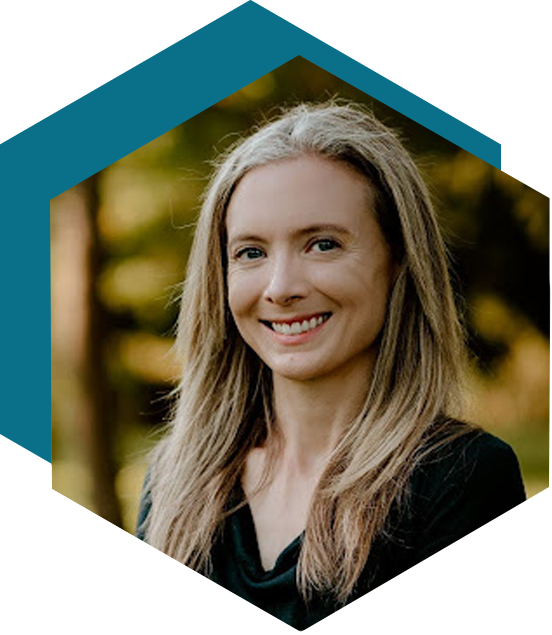 Blonde smiling woman with a blurred woods background within a hexagon