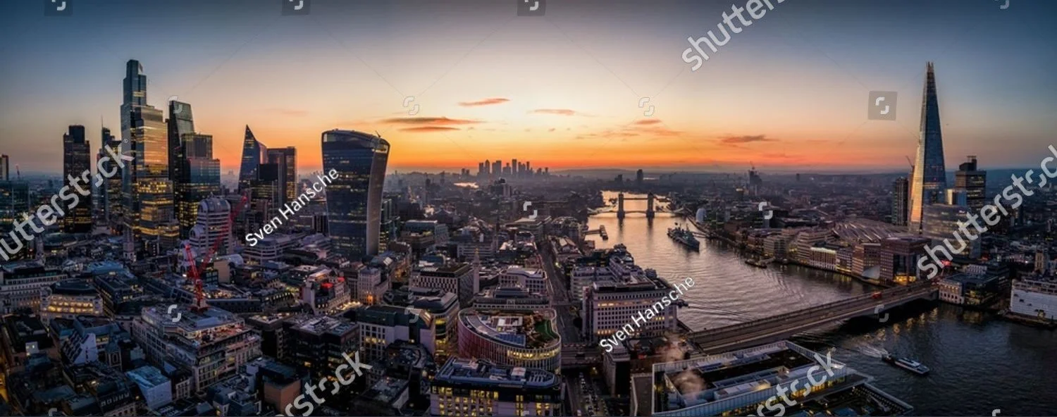 Aerial view of London skyline at sunset featuring Tower Bridge and tall skyscrapers including The Shard.