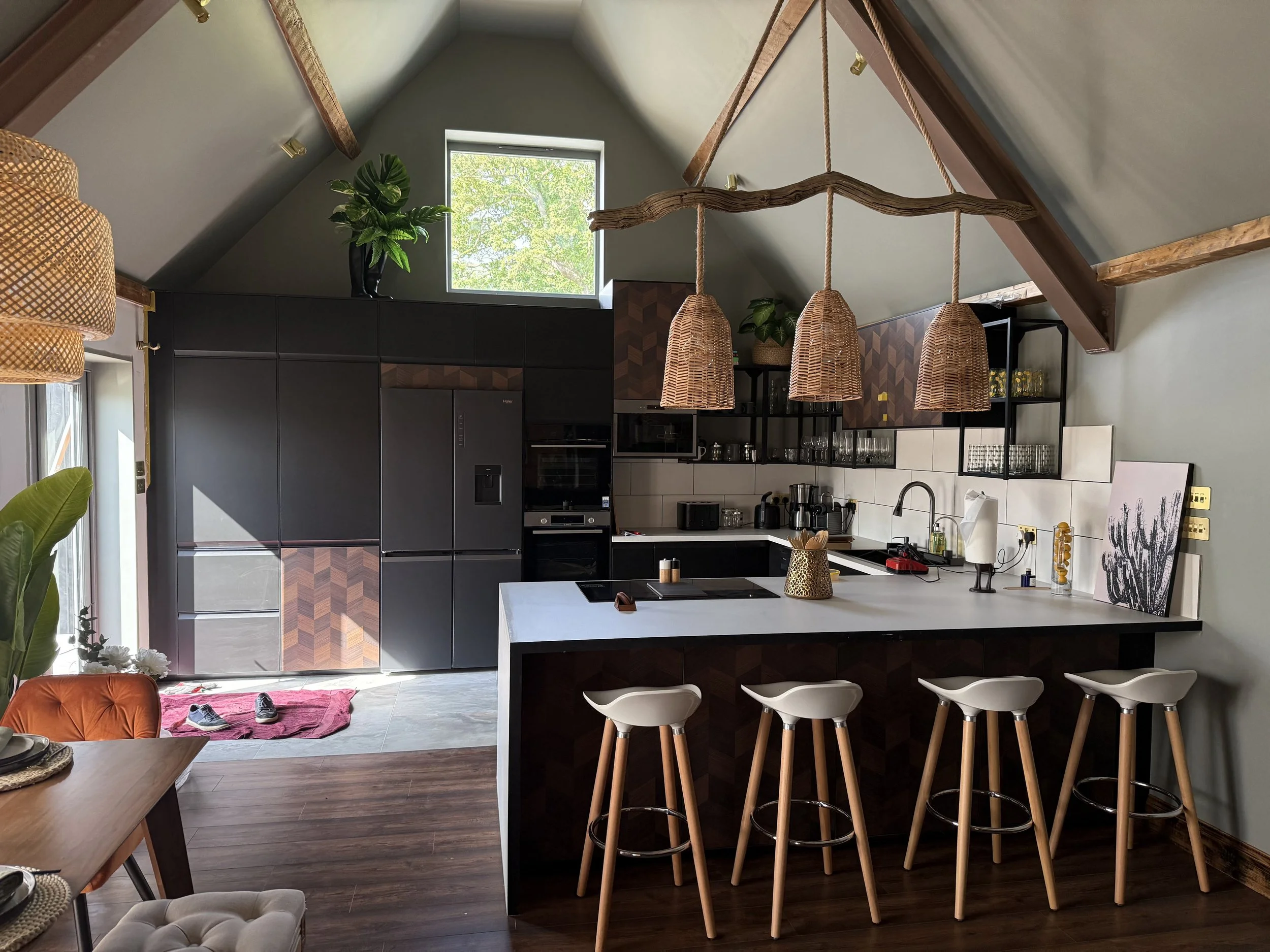 A modern kitchen with a dark cabinetry, wooden accents, and a breakfast bar
