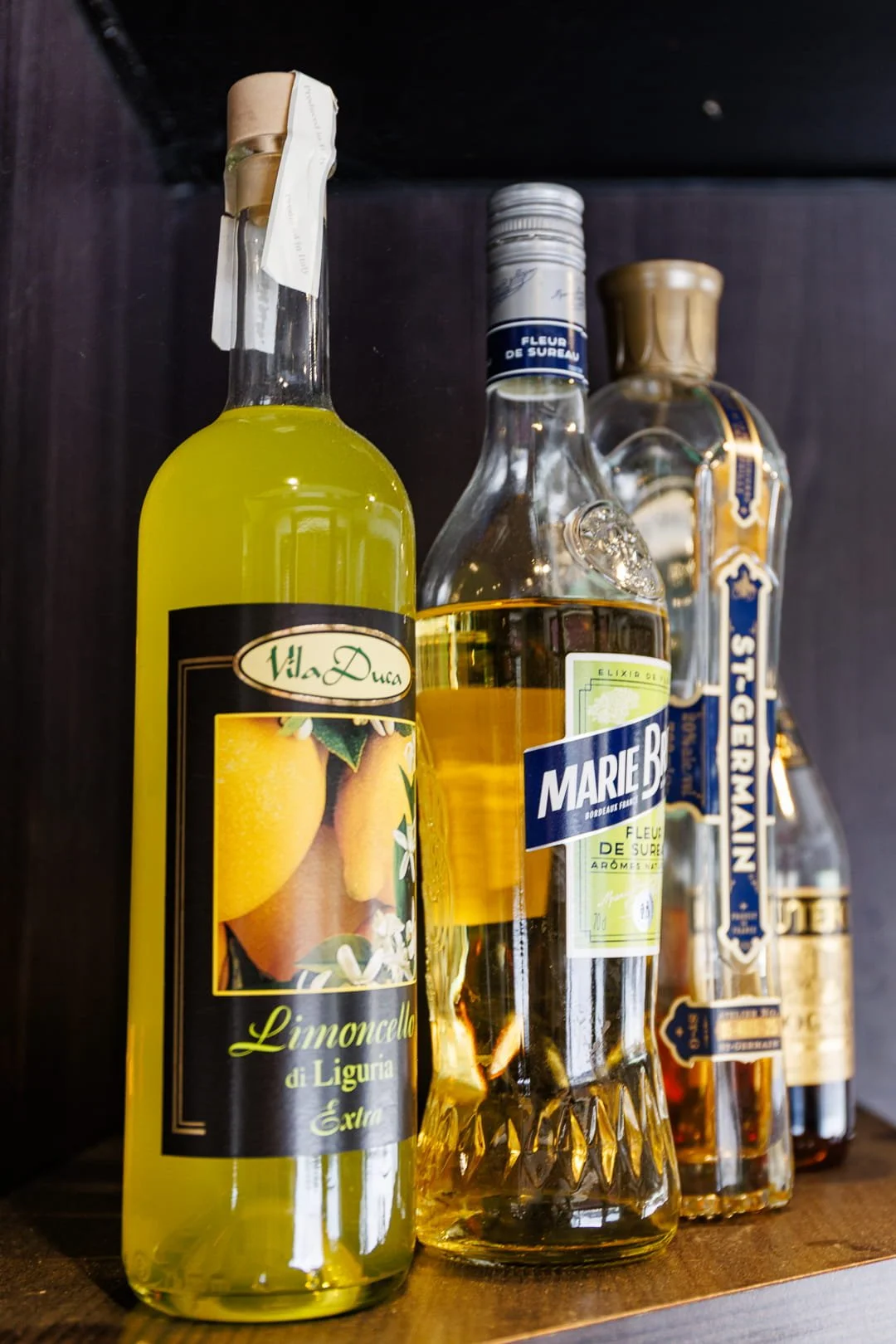 Bouteilles d'alcool, dont une bouteille de limoncello, et de liqueur, sur une étagère.