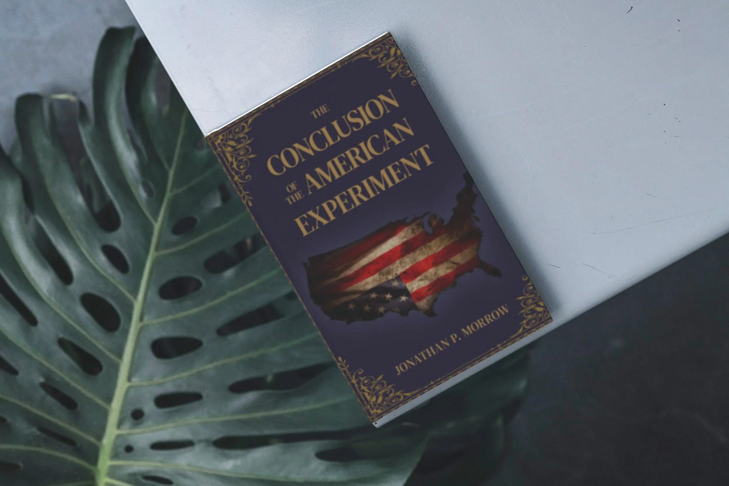 Book titled 'The Conclusion of the American Experiment' by Jonathan P. Morrow, with an illustration of the United States map overlayed with an American flag.