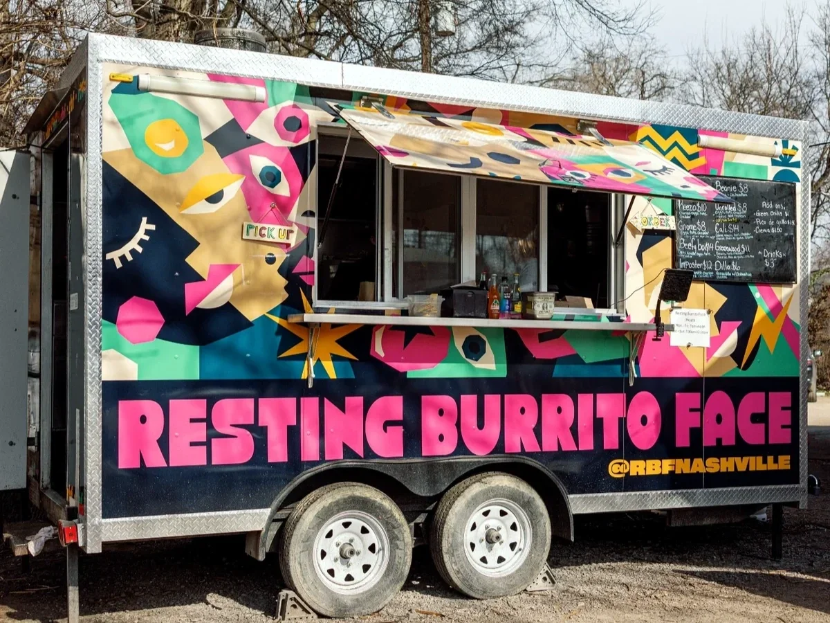 Food truck named 'Resting Burrito Face' with colorful graffiti-style artwork and a menu displayed on a blackboard.