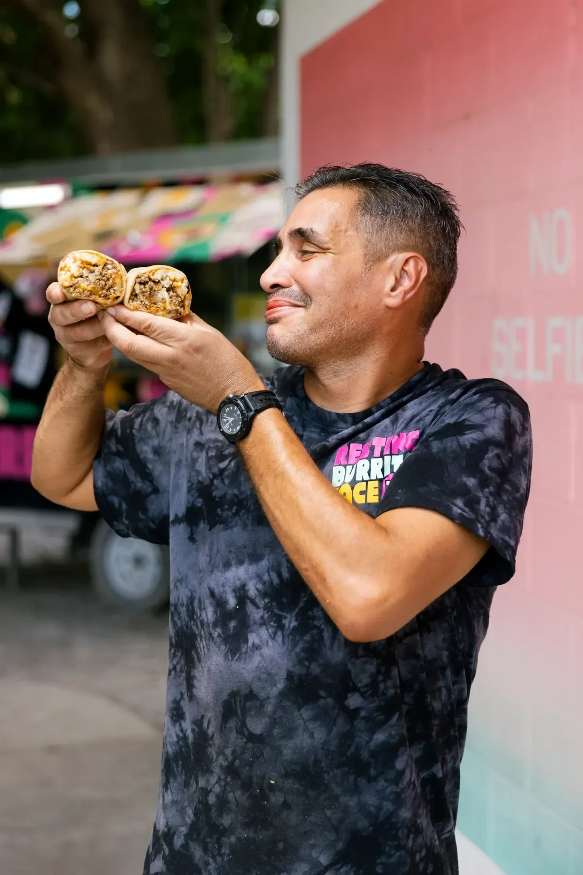 Resting Burrito Face team member holding a breakfast burrito outside the Nashville food truck