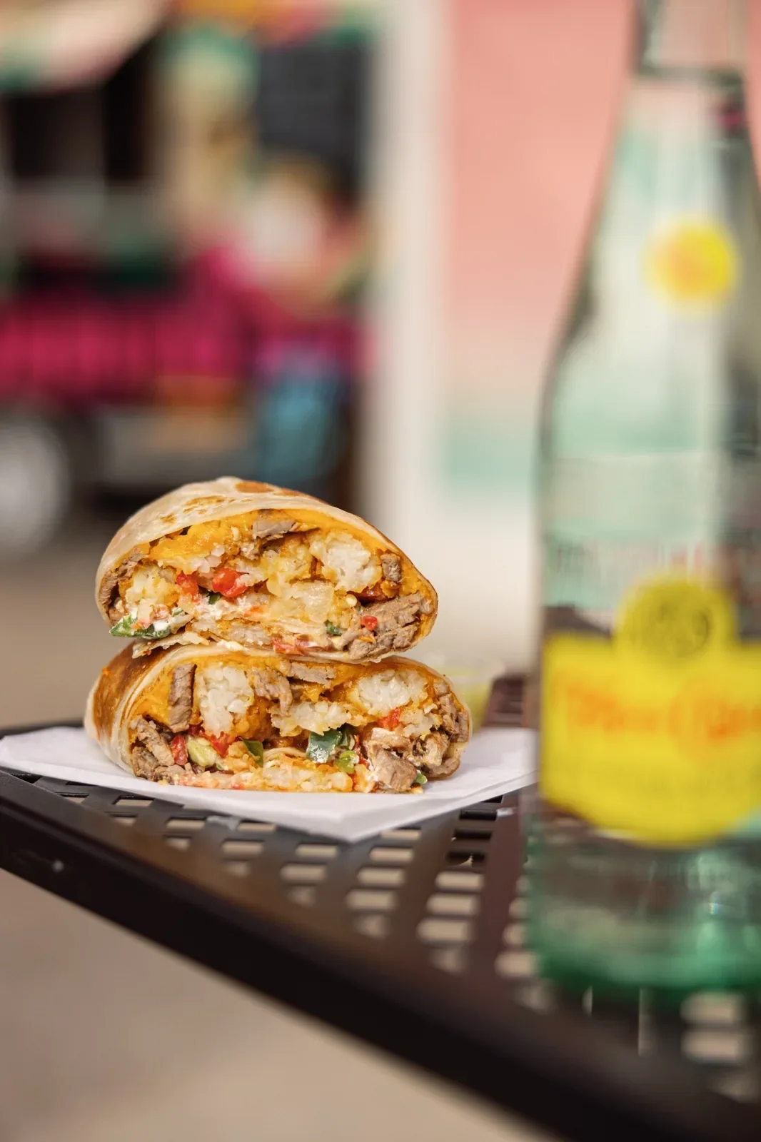 Closeup of a Resting Burrito Face breakfast burrito with a soda bottle in Nashville TN