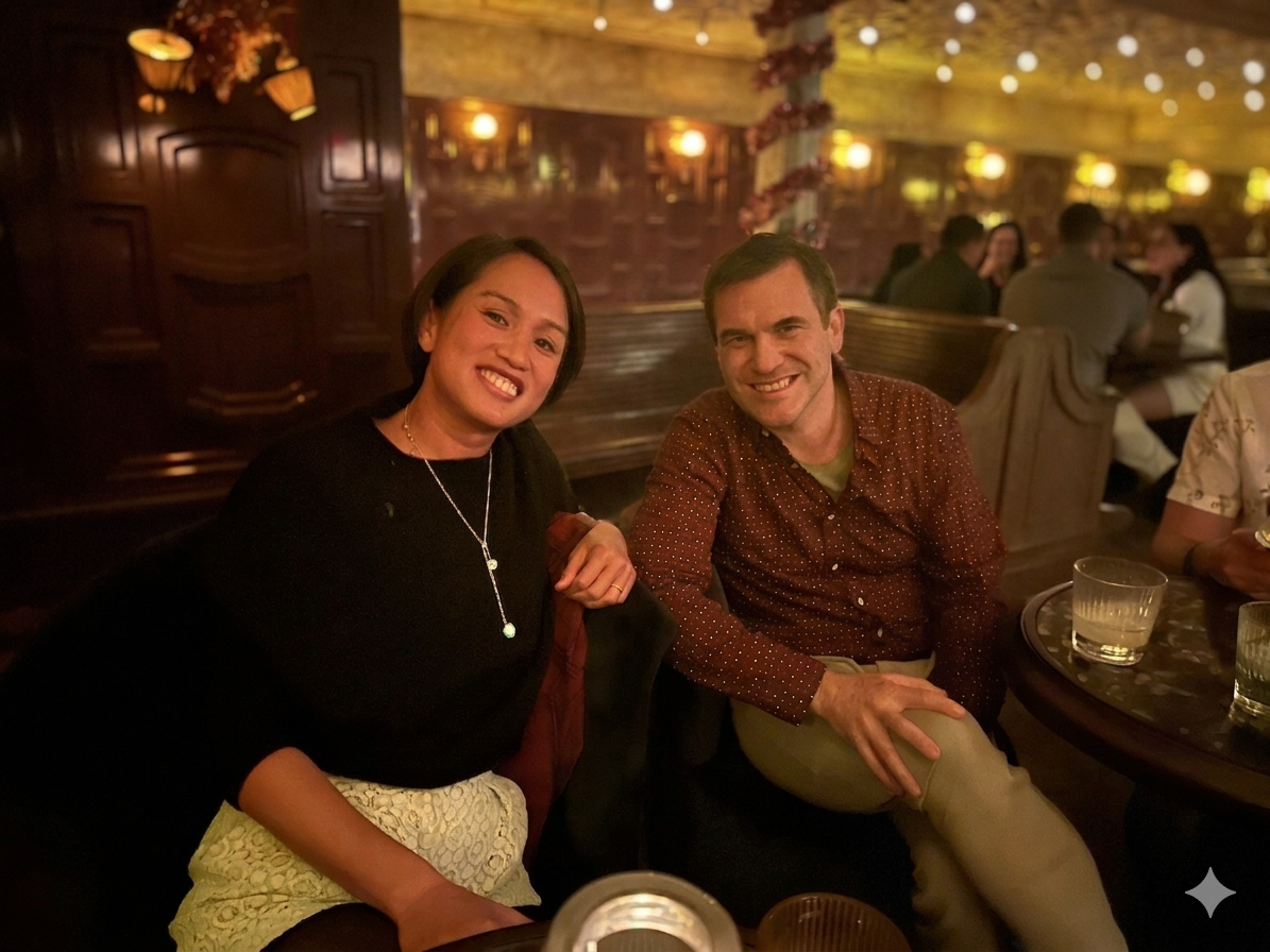 The founders, Ly and Dave, sitting at a table in a dimly-lit restaurant, smiling at the camera.