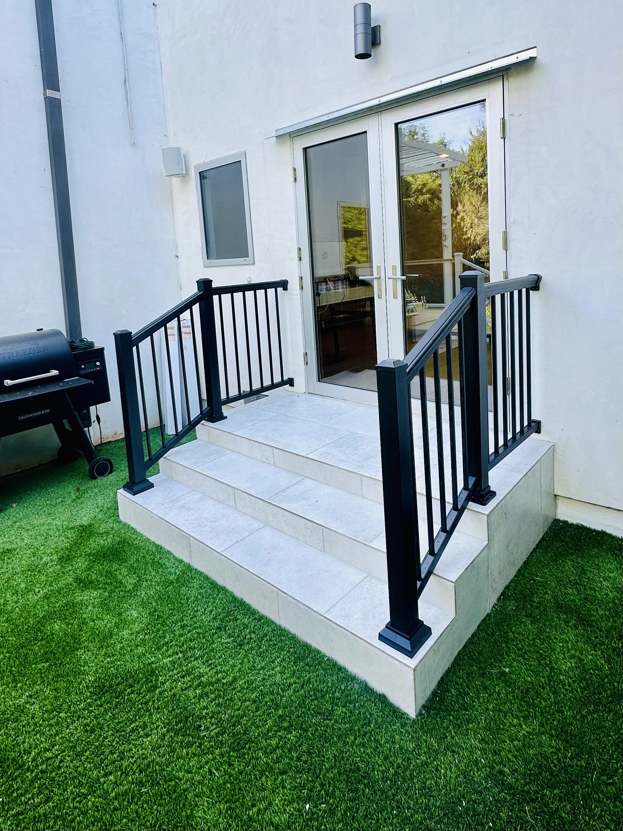 front porch rebuild with tiled steps and black handrails – residential project in LA