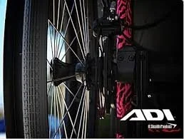 Close-up of a bicycle wheel and its hub, with a cow-print pink and black bike frame in the background, and the 'ADV' logo visible on the bike's frame.
