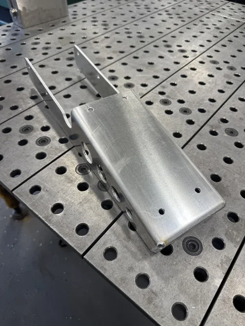 Metalwork fixture or jig on a perforated work surface.