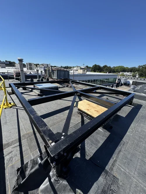 Rooftop with metal framework and equipment under a clear blue sky