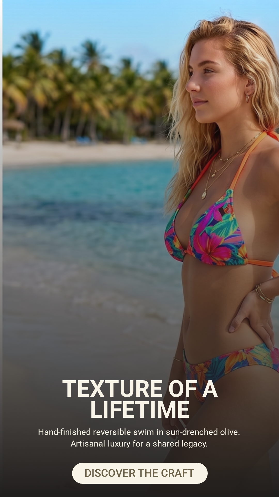 A woman in a colorful floral bikini with gold jewelry, standing on a beach with palm trees and ocean in the background.