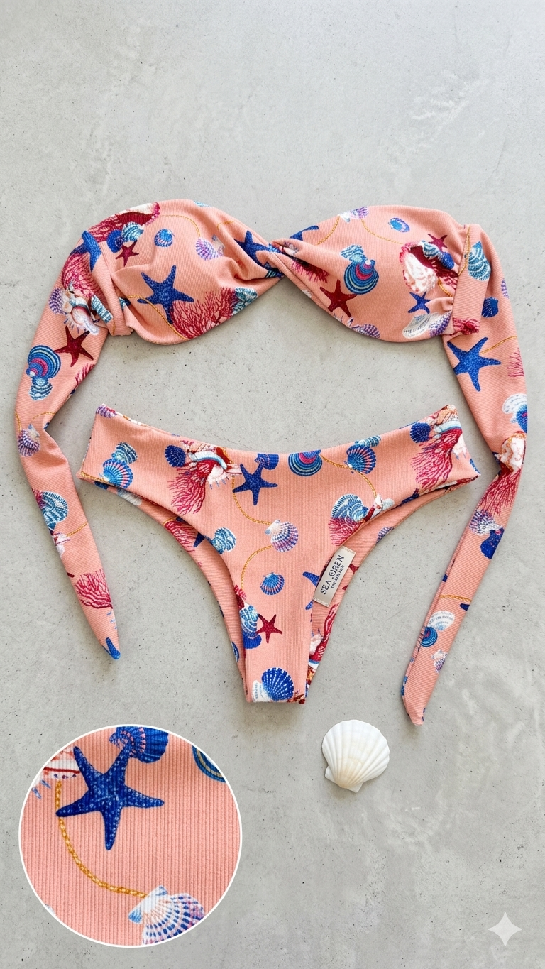 A pink bikini with a seashell and starfish pattern, laid out on a concrete surface, along with a white seashell.