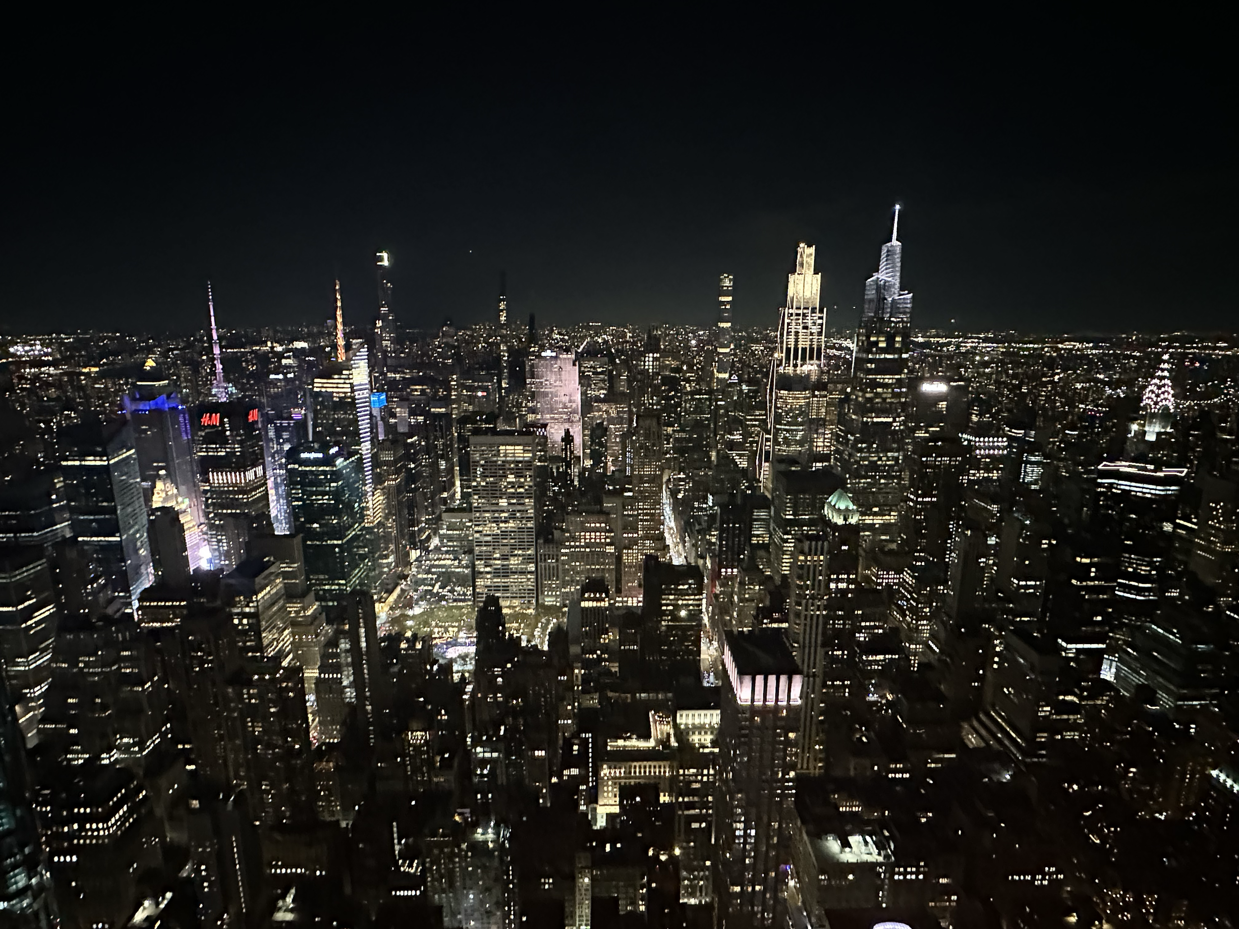 Nighttime cityscape of a downtown area with illuminated skyscrapers and buildings.