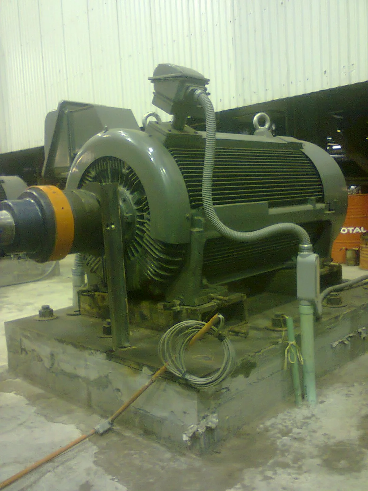 Motor eléctrico industrial en un taller con herramientas y cables alrededor.