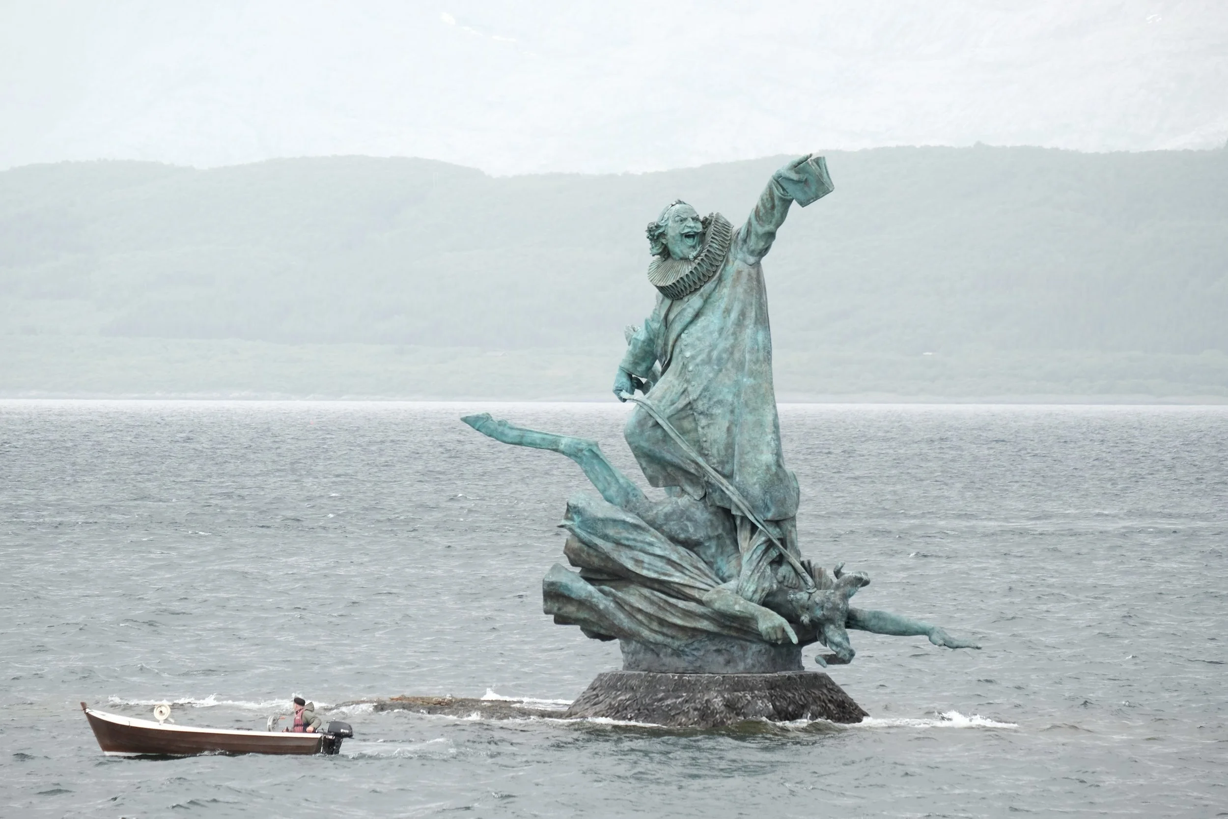Petter Dass monumentet, "Høyere opp og lengre fram, din Satan!", 10 meter høy bronseskulptur utført av kunsteren Frode Lillesund. båt ved monumentet som størrelse-referanse.