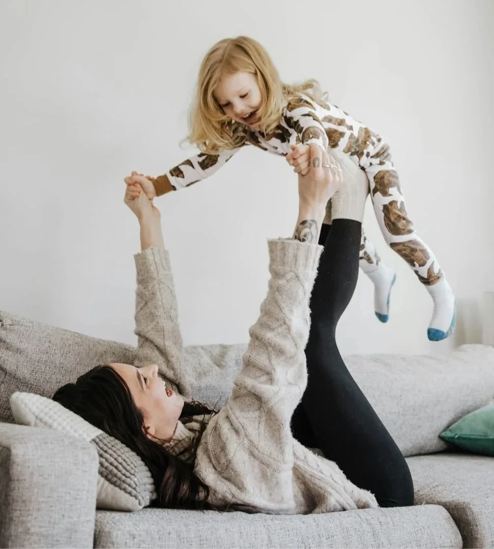 A mother and daughter playing together, sharing a joyful moment.