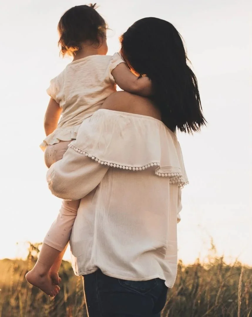 A mother holding her daughter capturing the warmth and connection that comes from flourishing in everyday moments.