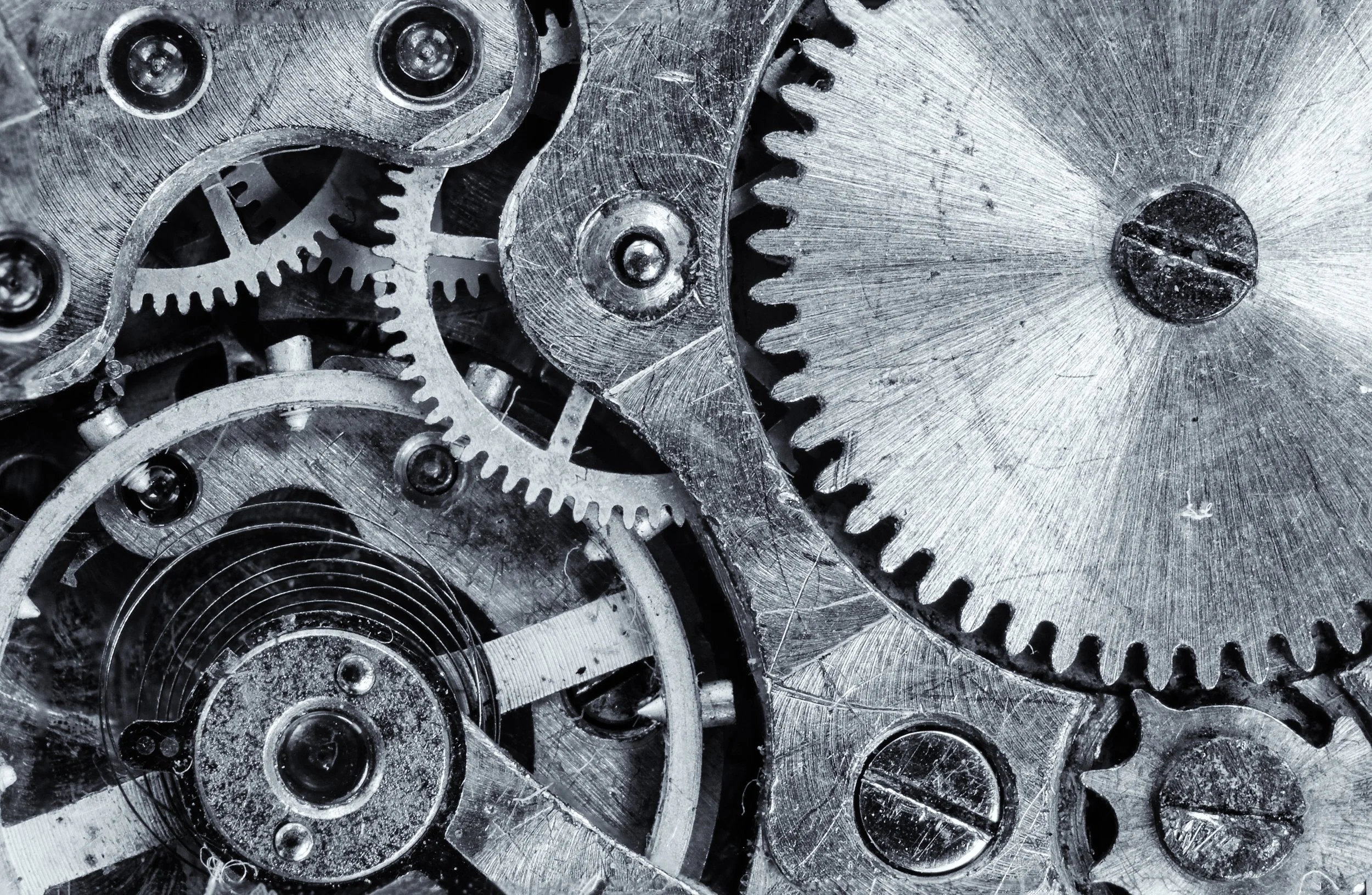 Close-up of interlocking metal gears and cogs with a metallic surface.