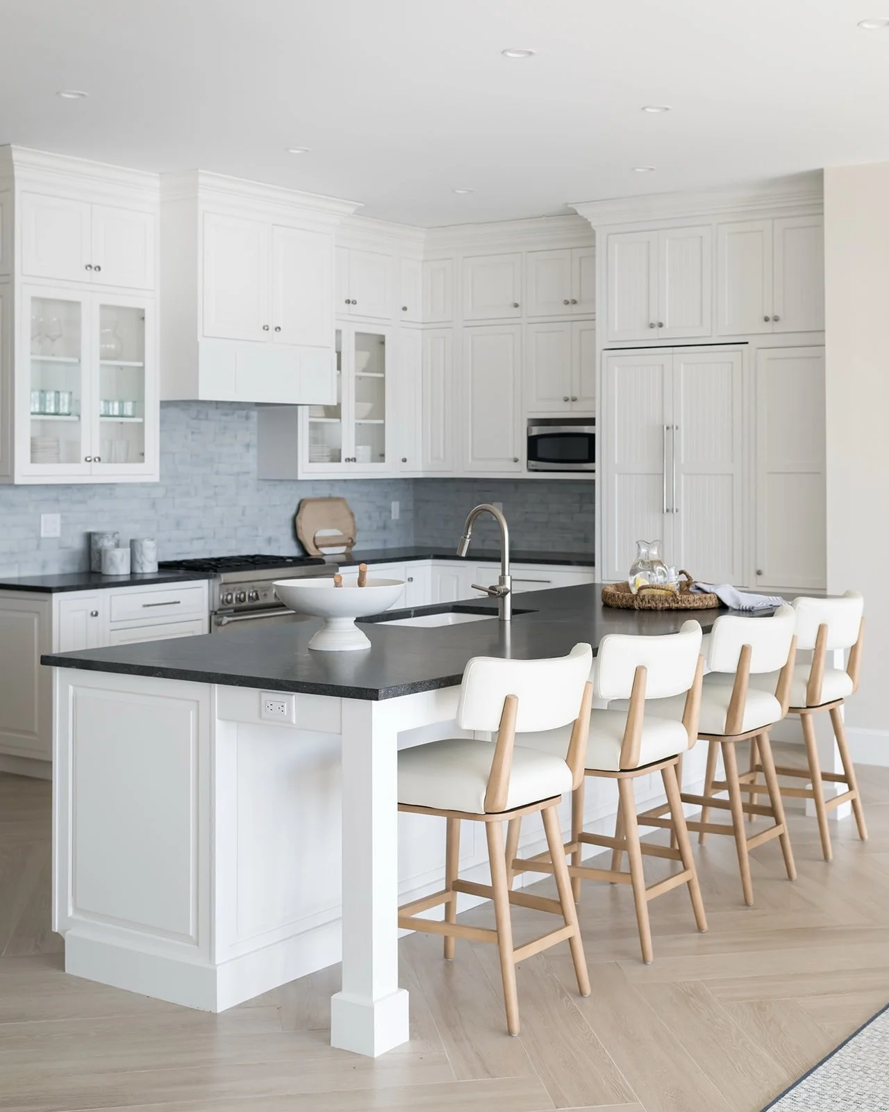 Would you believe me if I told you these are the same cabinets in both photos? We gave this kitchen a budget friendly update by painting the existing cabinets, reworking the hood and replacing the hardware, counter and backsplash. We created a long, 