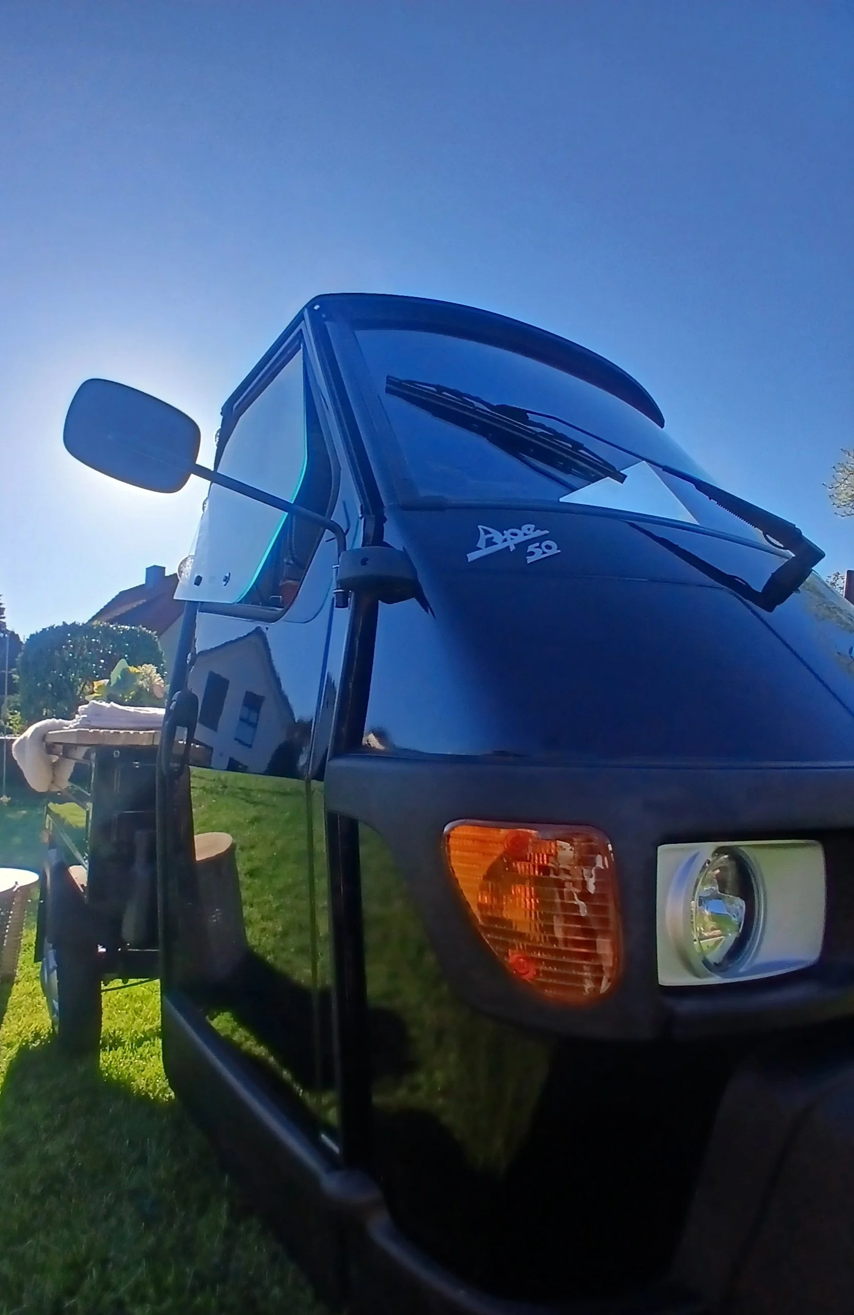 Nahaufnahme eines blauen Fahrzeugs mit dem Aufdruck 'Ape 50'.