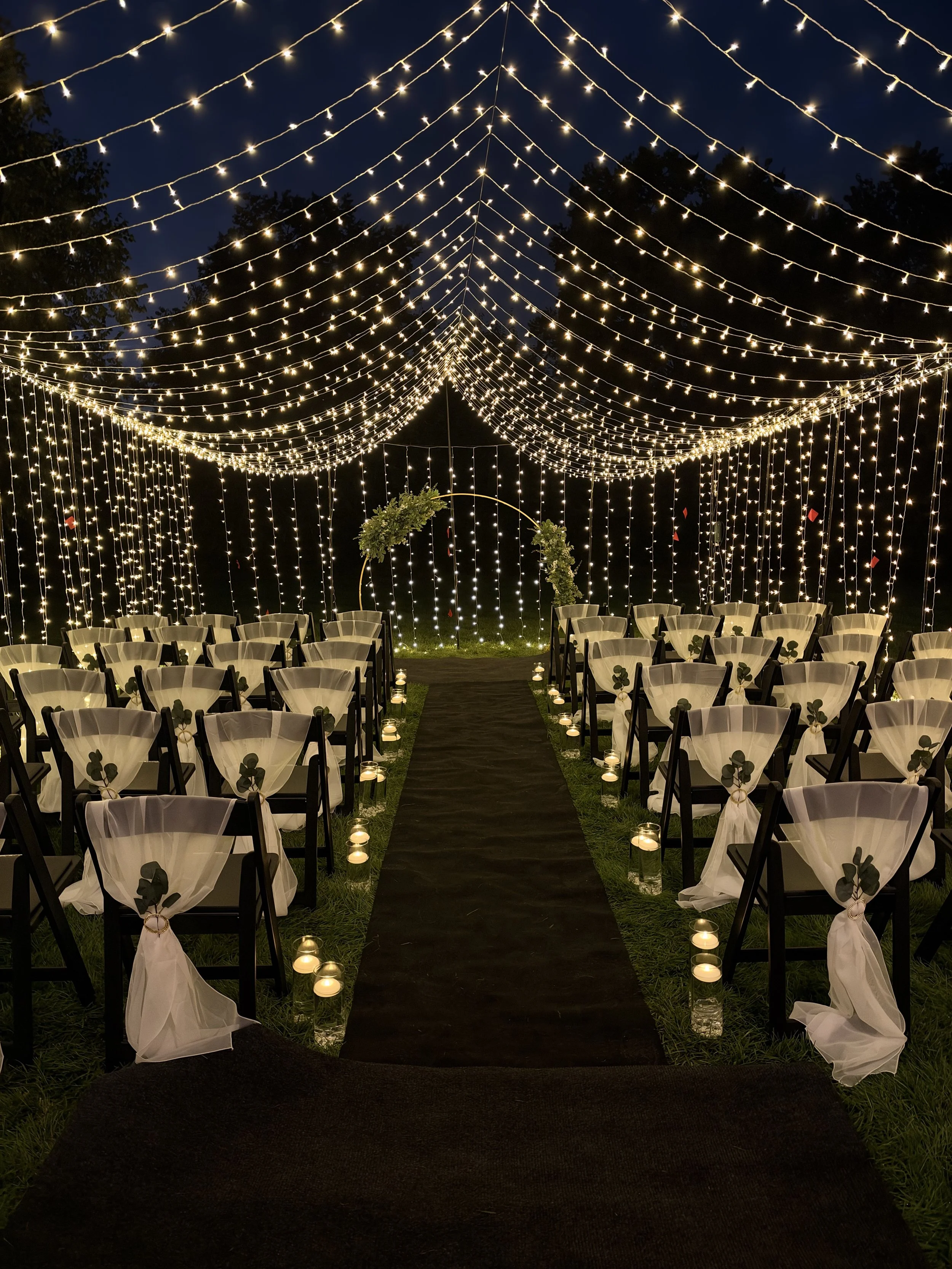 A candlelit aisle beneath a canopy of lights at a Kansas City vow renewal