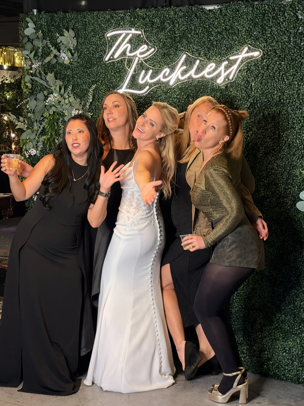 Guests posing in front of The Luckiest photo booth backdrop