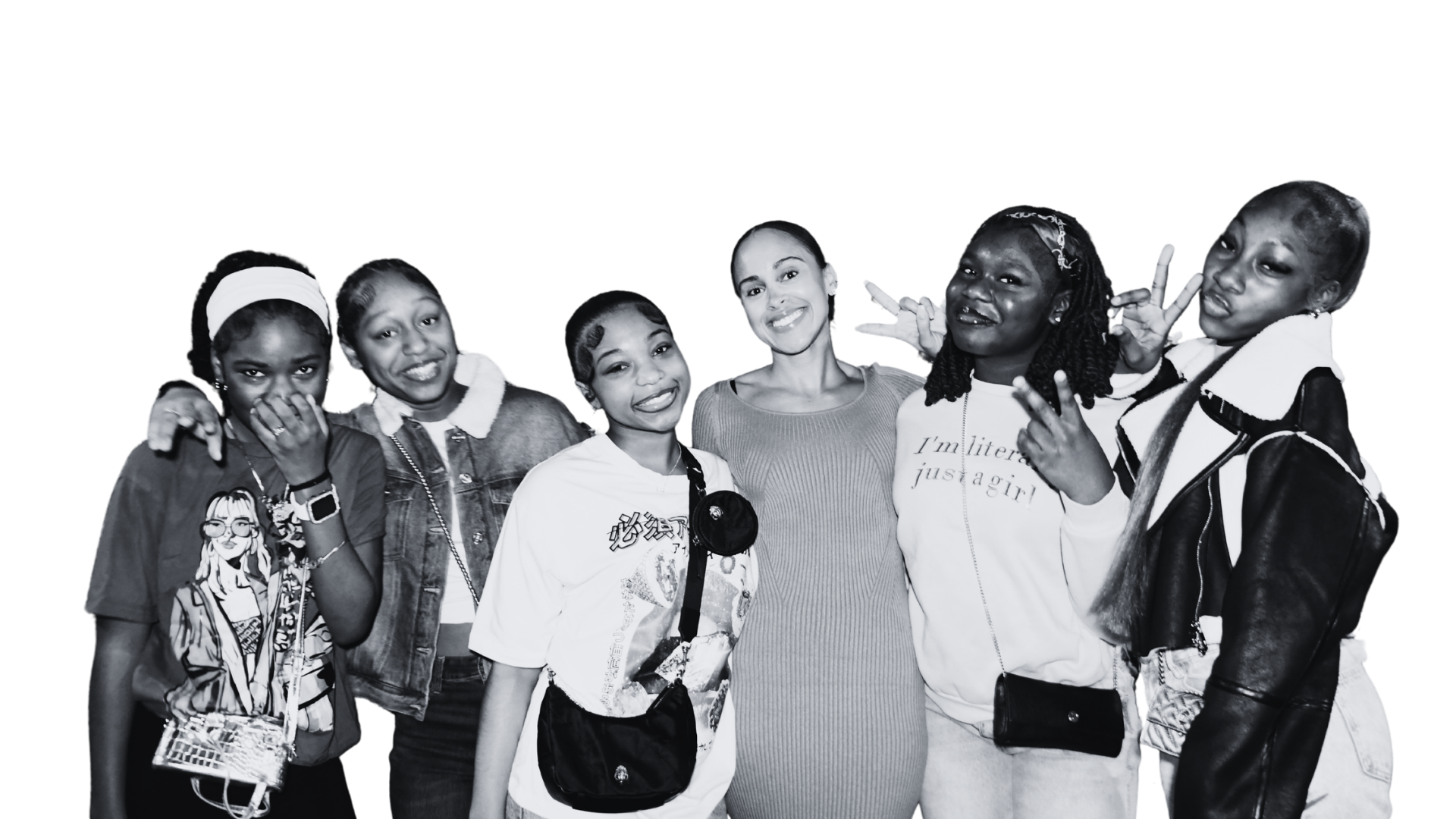 Black and white photo of seven diverse young girls and one woman standing together and smiling at the camera, some making peace signs.