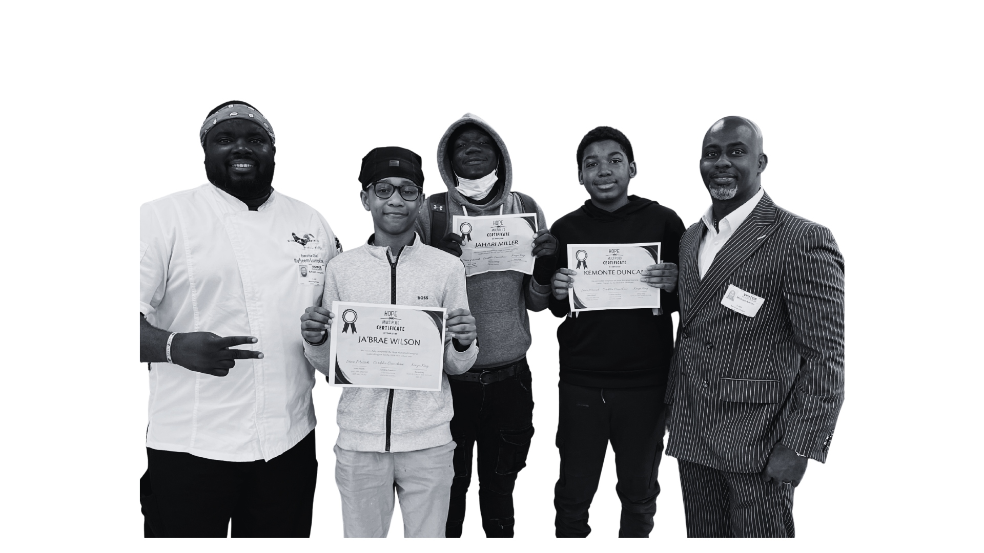 Group of five men standing together, holding certificates and smiling, in formal and casual attire, with some wearing ID badges.