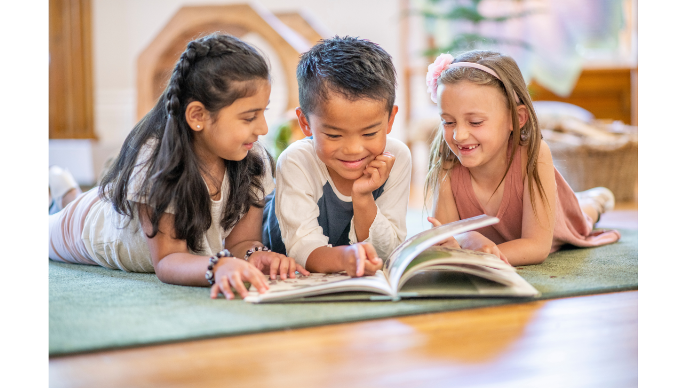 Three kids reading a book during a language literacy therapy session in St. Louis, MO
