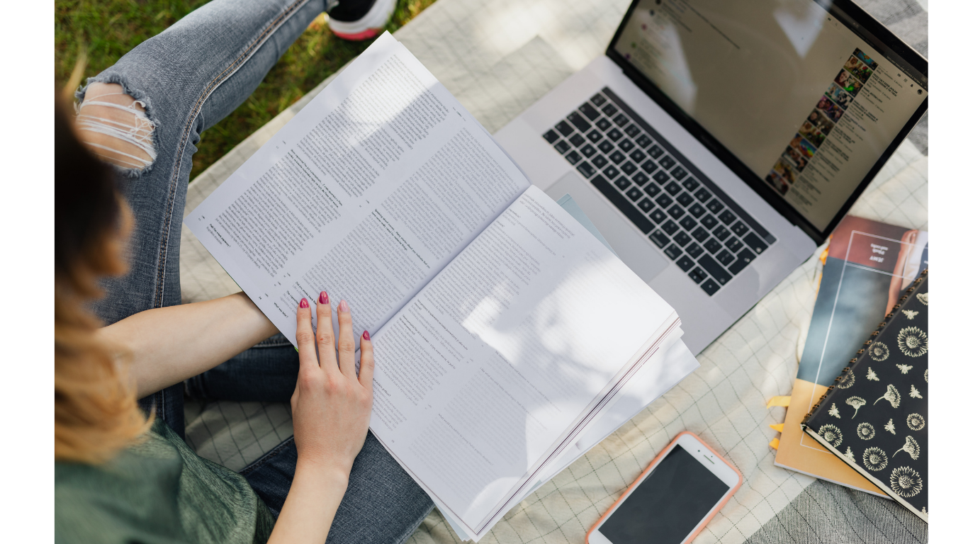 Parent with an open book and laptop reviewing language, literacy, and ADHD evaluation results in St. Louis, MO