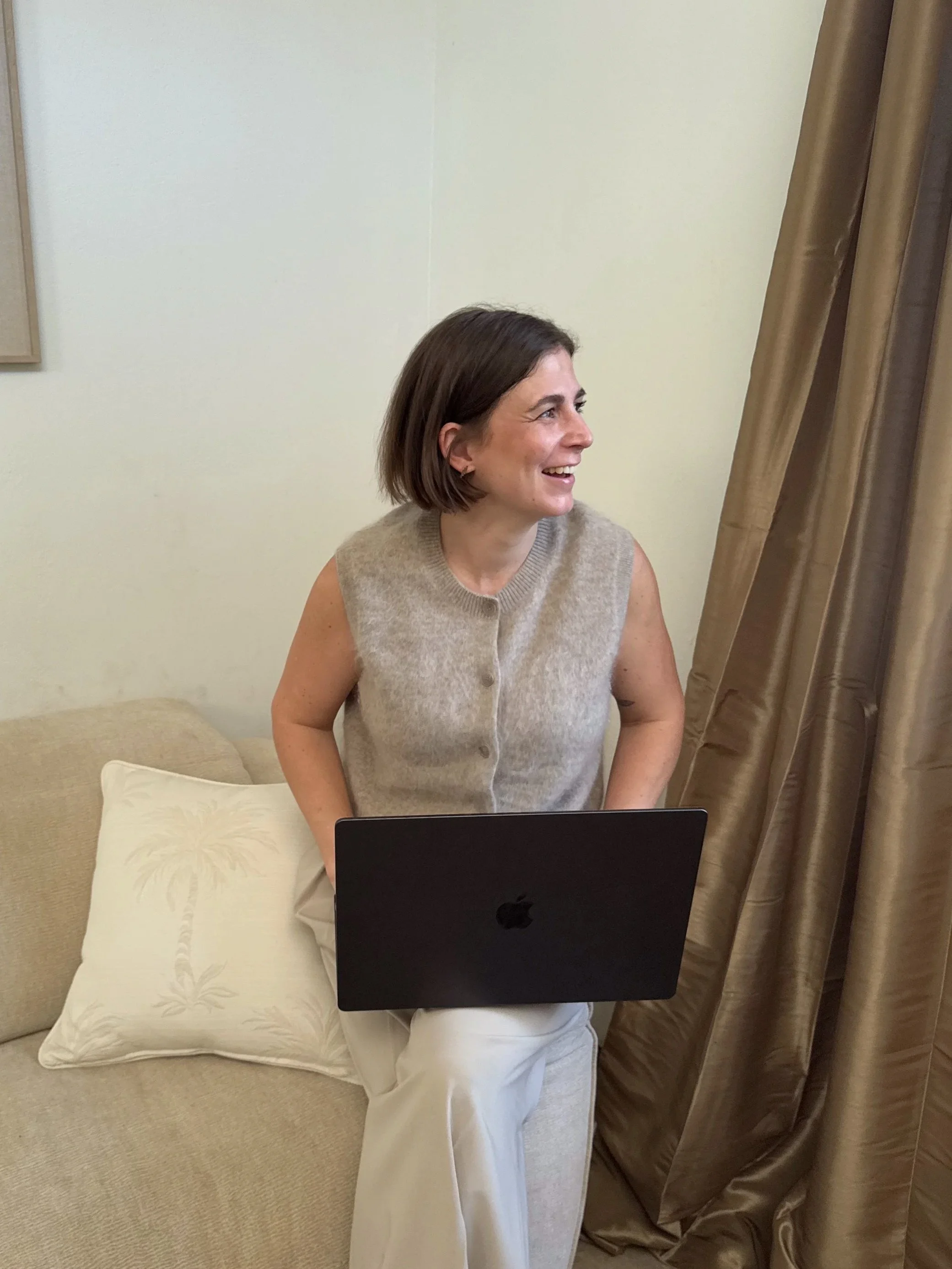 Woman learning interior design online using laptop on sofa