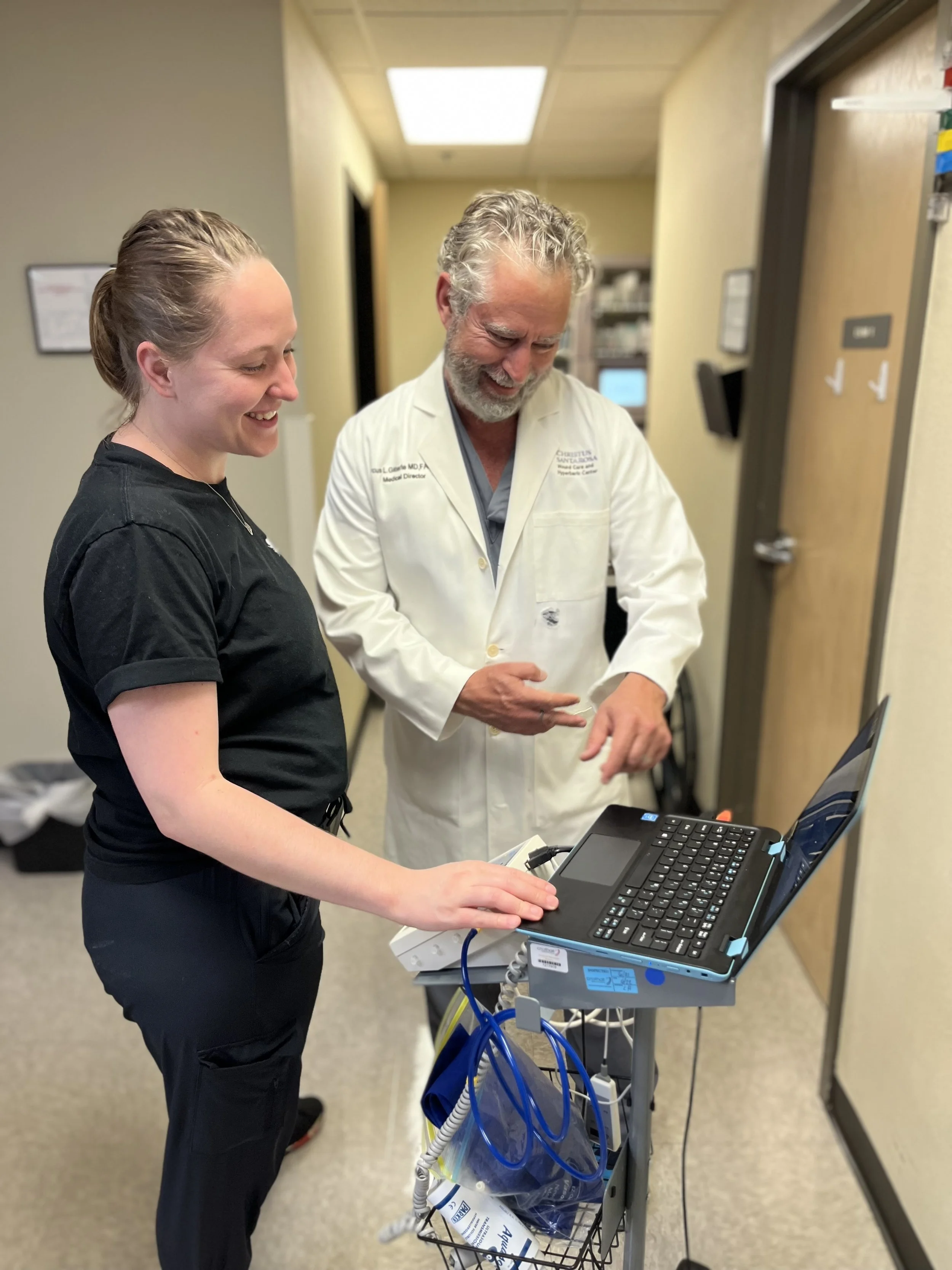 Dr. Gitterle and a younger healthcare provider reviewing clinical information in a wound clinic.